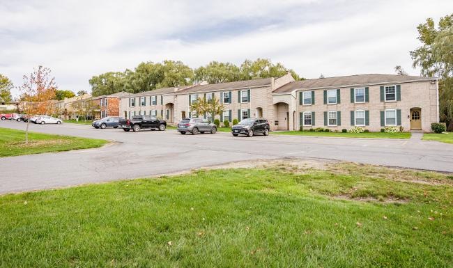 apartment building with cars parked in front