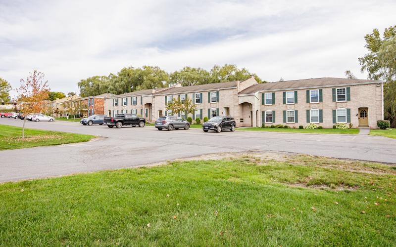 apartment building with cars parked in front